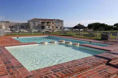 a large swimming pool with a brick floor at Unit 75 Hermanus Beach Club in Hermanus