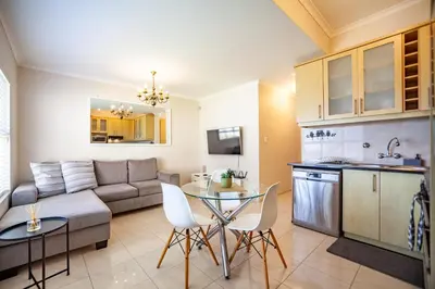 a living room with a couch and a table at Coral Breeze Walk to Everything in Cape Town