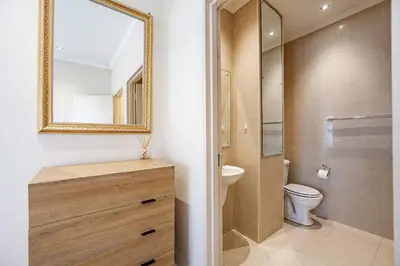 a bathroom with a sink and a toilet and a mirror at Coral Breeze Walk to Everything in Cape Town