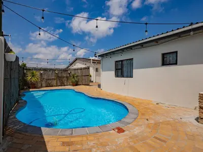 a swimming pool in the backyard of a house at La Bella Vida Self Catering Apartments in Bellville