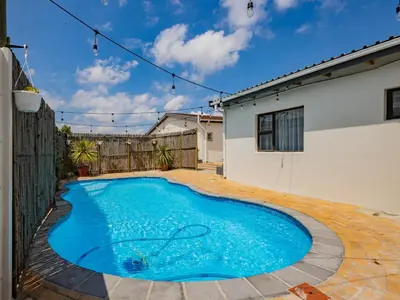 a swimming pool in the backyard of a house at La Bella Vida Self Catering Apartments in Bellville