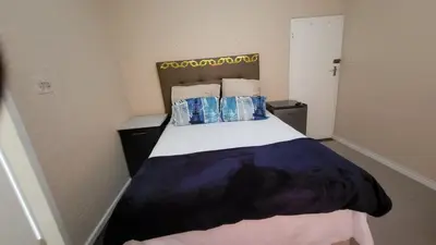 a small bedroom with a bed with blue pillows at The Vasco in Cape Town