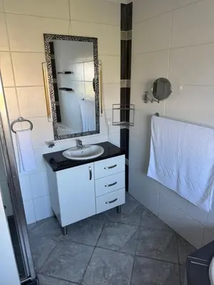 a bathroom with a sink and a mirror at Shalom in Cape Town