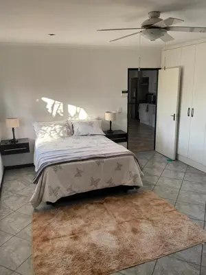 a bedroom with a large bed and a rug at Shalom in Cape Town