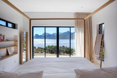a bedroom with a bed and a view of the ocean at Villa Sur La Mer in Pringle Bay