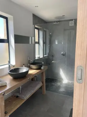 a bathroom with two sinks and a shower at Villa Sur La Mer in Pringle Bay