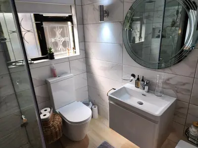 a bathroom with a toilet and a sink and a mirror at Le Graan Guestroom in Malmesbury