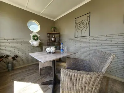 a dining room with a table and two chairs at Le Graan Guestroom in Malmesbury