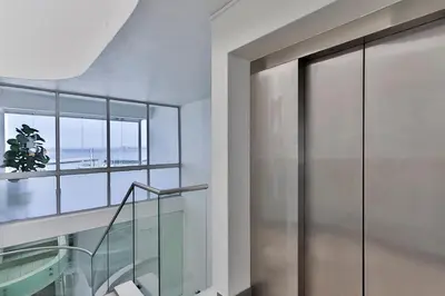 a glass staircase in a building with a window at 34 Gordonia, Beachfront Penthouse in Gordonʼs Bay