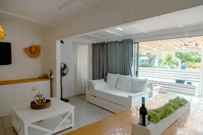 a living room with a white couch and a table at The Ocean Side Cottage in Cape Town