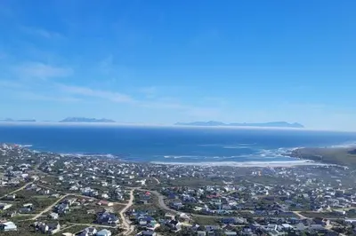 an aerial view of a city and the ocean at Paradise 'tween sea and mountain in Pringle Bay