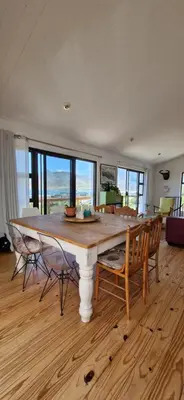 a dining room with a large table and chairs at Paradise 'tween sea and mountain in Pringle Bay