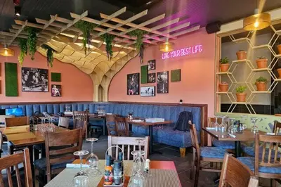 a restaurant with tables and chairs in a room at Tyger waterfront apartment in Cape Town