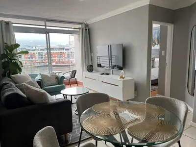 a living room with a couch and a table at Tyger waterfront apartment in Cape Town