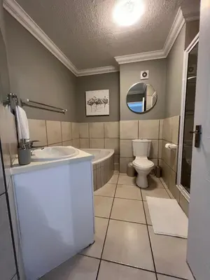 a bathroom with a sink and a tub and a toilet at Tyger waterfront apartment in Cape Town