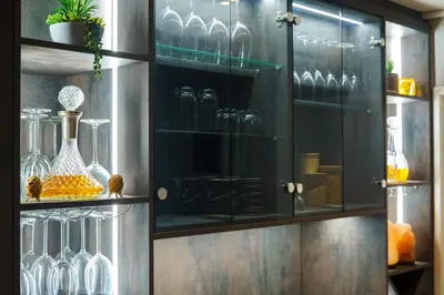 a glass cabinet with glasses and vases in it at Tyger Lake Luxury Loft in Cape Town