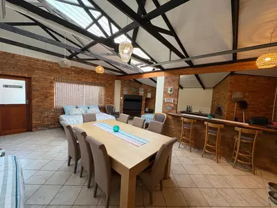 a large dining room with a table and chairs at Onrus Beach House in Hermanus