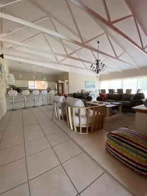 a living room with a couch and a table and chairs at Onrus Beach House in Hermanus