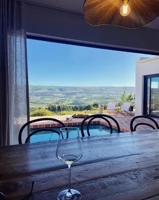 a wine glass sitting on top of a wooden table at Spioenkop Wines Farm House in Elgin