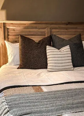 a bed with a wooden headboard and pillows on it at 7 on Huis Piron in Stellenbosch