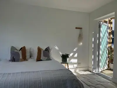 a bedroom with a bed with pillows on it at Sunset Studios in Cape Town