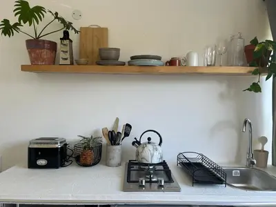 a kitchen counter with a stove and a sink at Sunset Studios in Cape Town