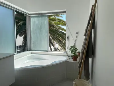 a bath tub in a bathroom with a window at Sunset Studios in Cape Town