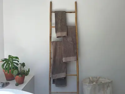 a wooden towel rack with towels on a wall at Sunset Studios in Cape Town