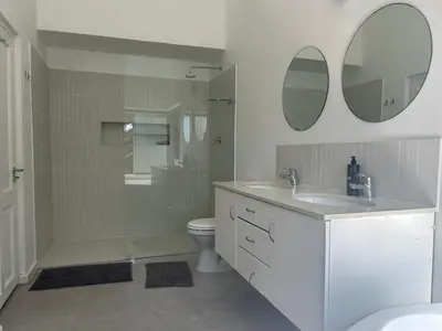 a bathroom with a shower and a sink and a toilet at Sunset Studios in Cape Town