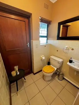 a bathroom with a toilet with a wooden seat at Gordon's Bay Townhouse in Gordonʼs Bay