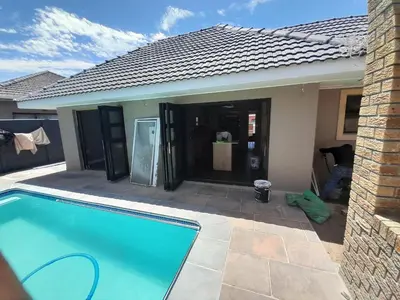 a swimming pool in front of a house at Nana Guest House in Cape Town