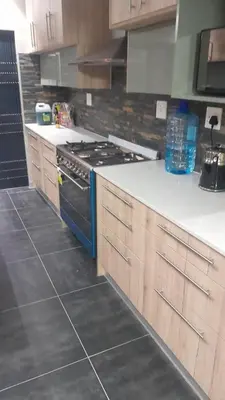 a kitchen with wooden cabinets and a stove top oven at Nana Guest House in Cape Town