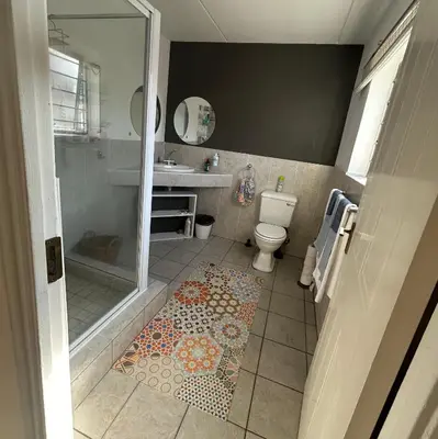 a bathroom with a shower and a toilet and a sink at Serene Studio in Cape Town
