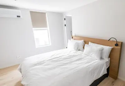 a bedroom with a white bed with white sheets and pillows at Ocean 9 - Sunset Beachfront Apartments in Cape Town