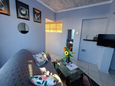a living room with a couch and a table at Oakway Guest Suite in Cape Town