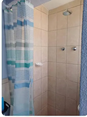 a shower with a blue and white shower curtain at Oakway Guest Suite in Cape Town