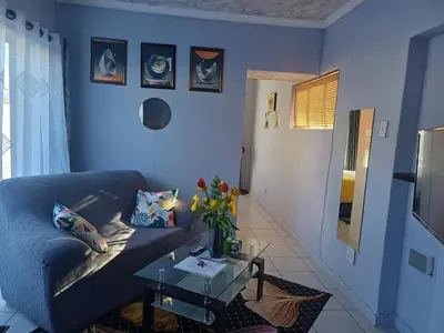a blue living room with a couch and a table at Oakway Guest Suite in Cape Town