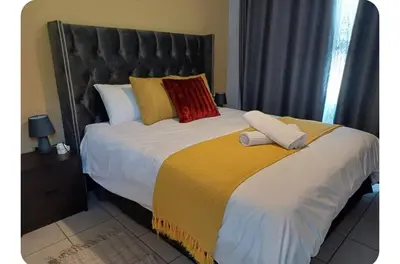 a bedroom with a large bed with a black headboard at Oakway Guest Suite in Cape Town