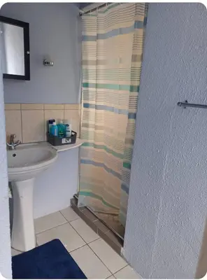 a bathroom with a shower curtain and a sink at Oakway Guest Suite in Cape Town