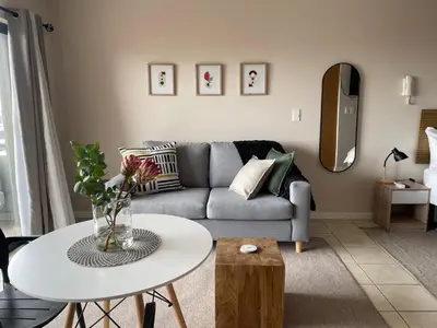 a living room with a couch and a table at Studio in the City in Cape Town