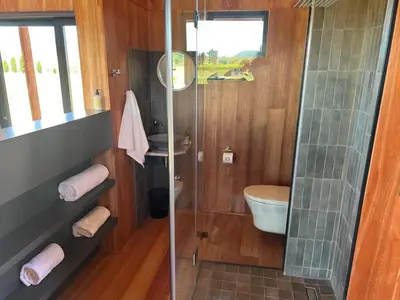 a bathroom with a glass shower and a toilet at Natimby Lodge in Botrivier