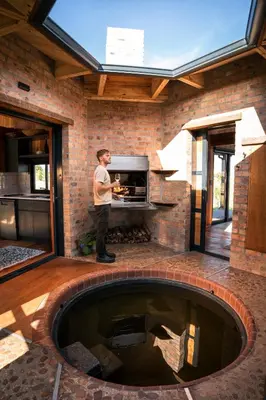 a man standing in front of a brick fireplace at Natimby Lodge in Botrivier