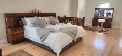 a bedroom with a large bed with two towels on it at Stellenbosch Paradijs Family-home in Stellenbosch