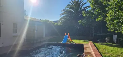 a swimming pool with a toy in a yard at Stellenbosch Paradijs Family-home in Stellenbosch
