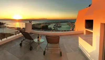 a balcony with a view of a marina at sunset at Bikini Beach Townhouse in Gordonʼs Bay