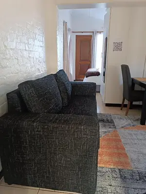 a living room with a couch and a bedroom at The Berna in Cape Town
