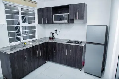 a kitchen with wooden cabinets and a refrigerator at one bedroom apartment A1 in Cape Town