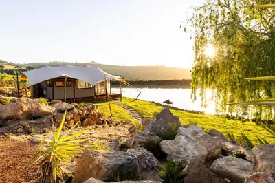a luxury tent on the shore of a lake at Amperbo Glamping in Cape Town