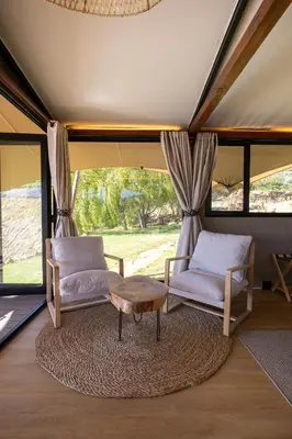 a room with two chairs and a table and windows at Amperbo Glamping in Cape Town