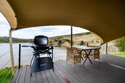 a deck with a grill and a table on a boat at Amperbo Glamping in Cape Town